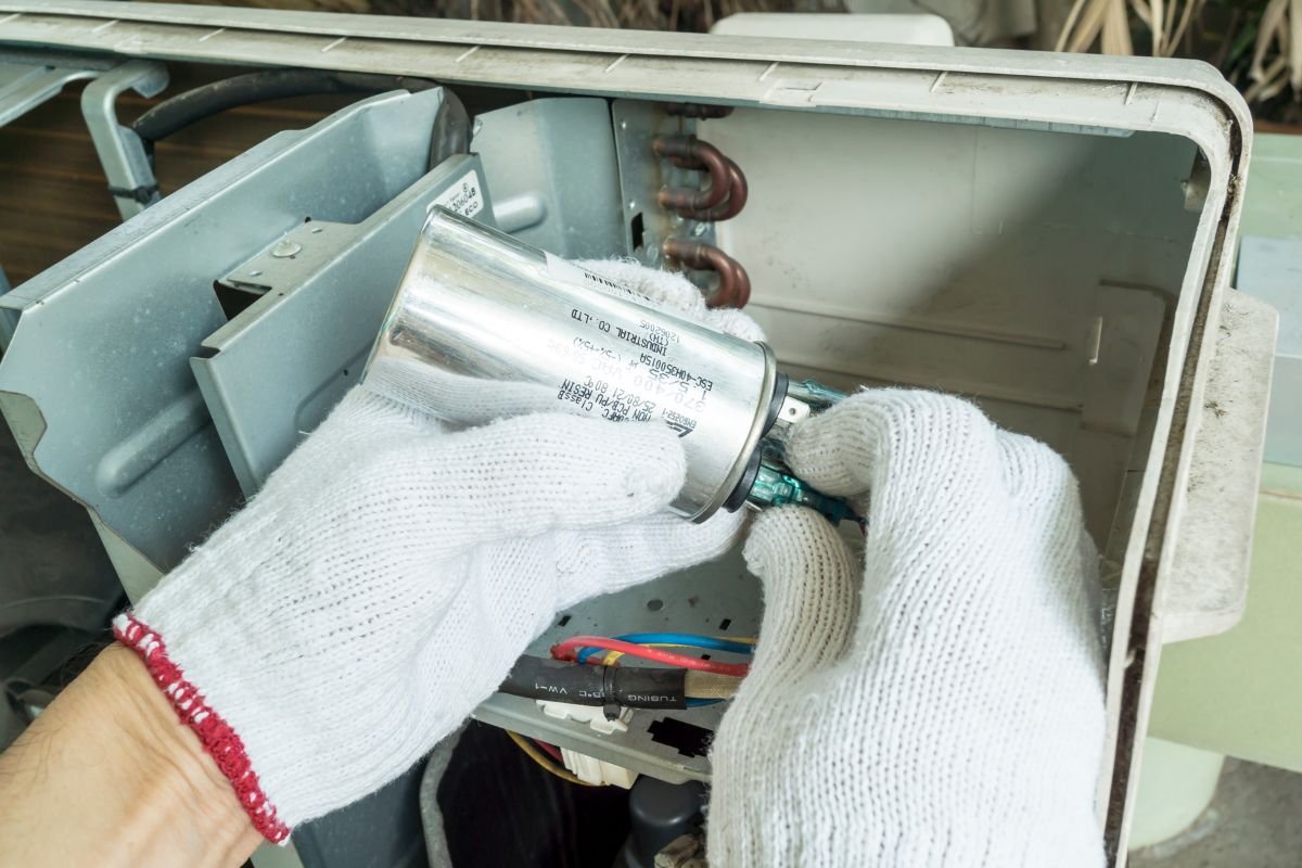 A professional holding an ac capacitor to show how to test ac capacitor