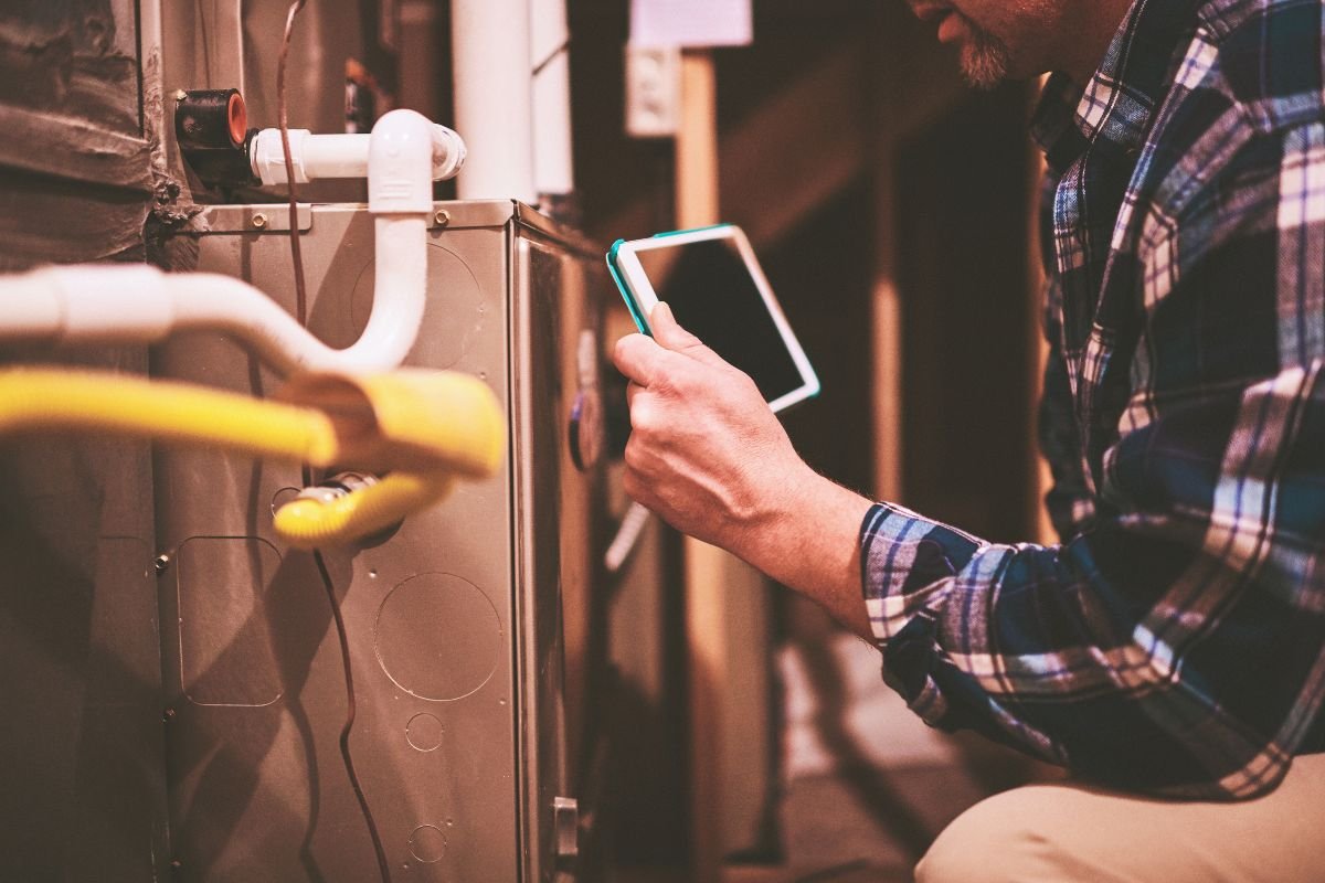 A technician checking and teaching how to troubleshoot common issues with furnace flame sensors