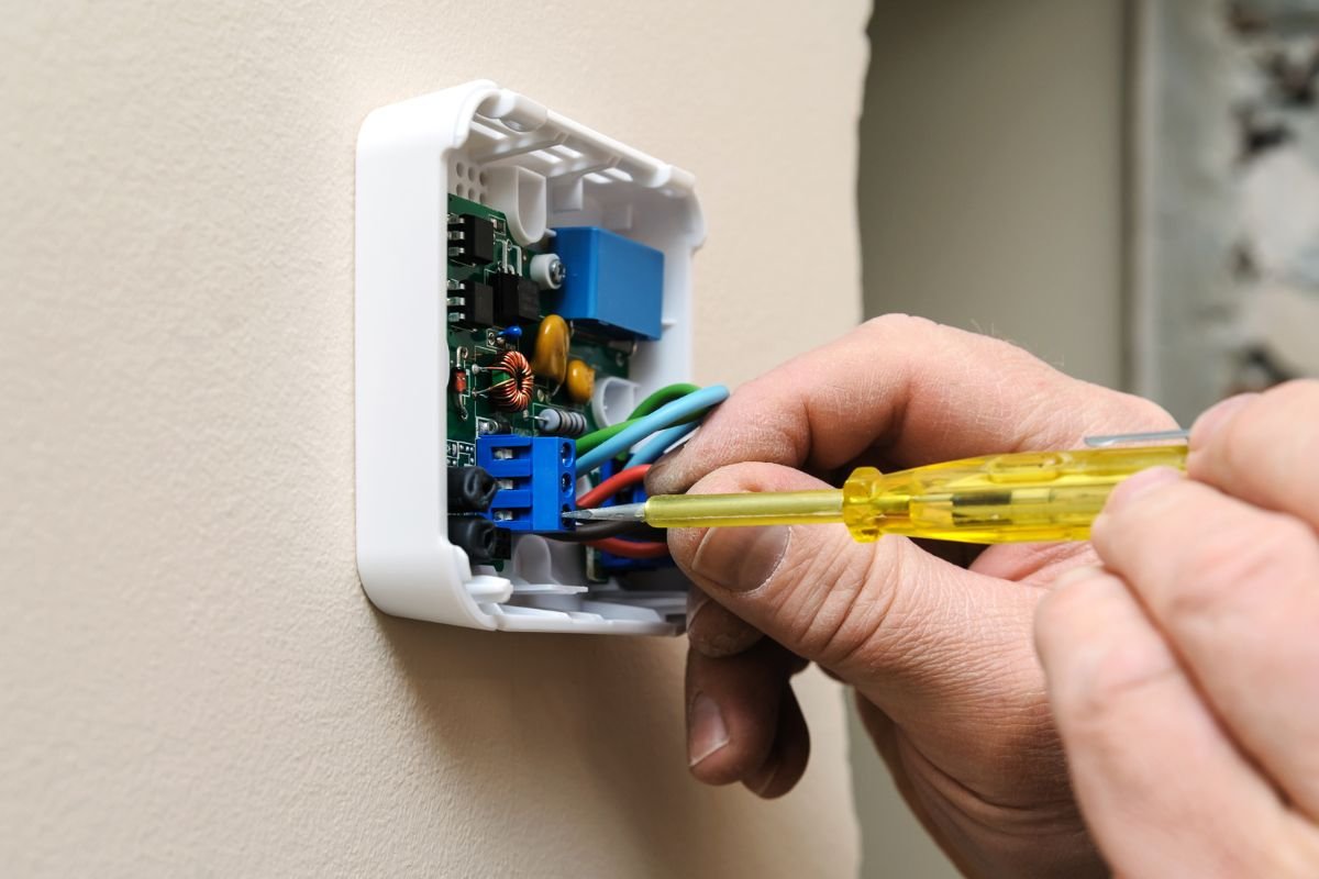 A thermostat wiring being inspected by an HVAC professional